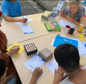 Die Großen spielen begeistert Stadt-Land-Fluss, Mutter und Kind spielen Boggle.